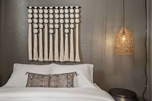 A bed with white linens, a decorative wall hanging, and a woven light fixture. - Hot Tub, Sauna & Game Room Mountain-View Home (Westminster)