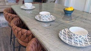 A dining table with patterned tableware, brown upholstered chairs, and a bowl of lemons. - The Still Waters Cottage (Evart)