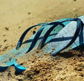 A blue flip-flop lying on sandy ground. - BUNGALOW DE SAINT JACQUES (Saint-François)