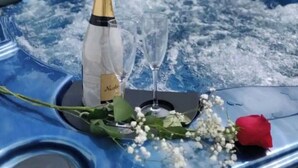 Een jacuzzi met champagne, een glas en een roos op ijs.
