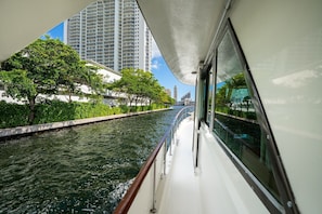A river with a boat, buildings, and trees along the banks.