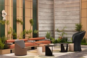 A modern lounge area with a sofa, chairs, a table, and decorative plants. - Hilton Garden Inn Chengdu Jinnan Tianjie (Chengdu)