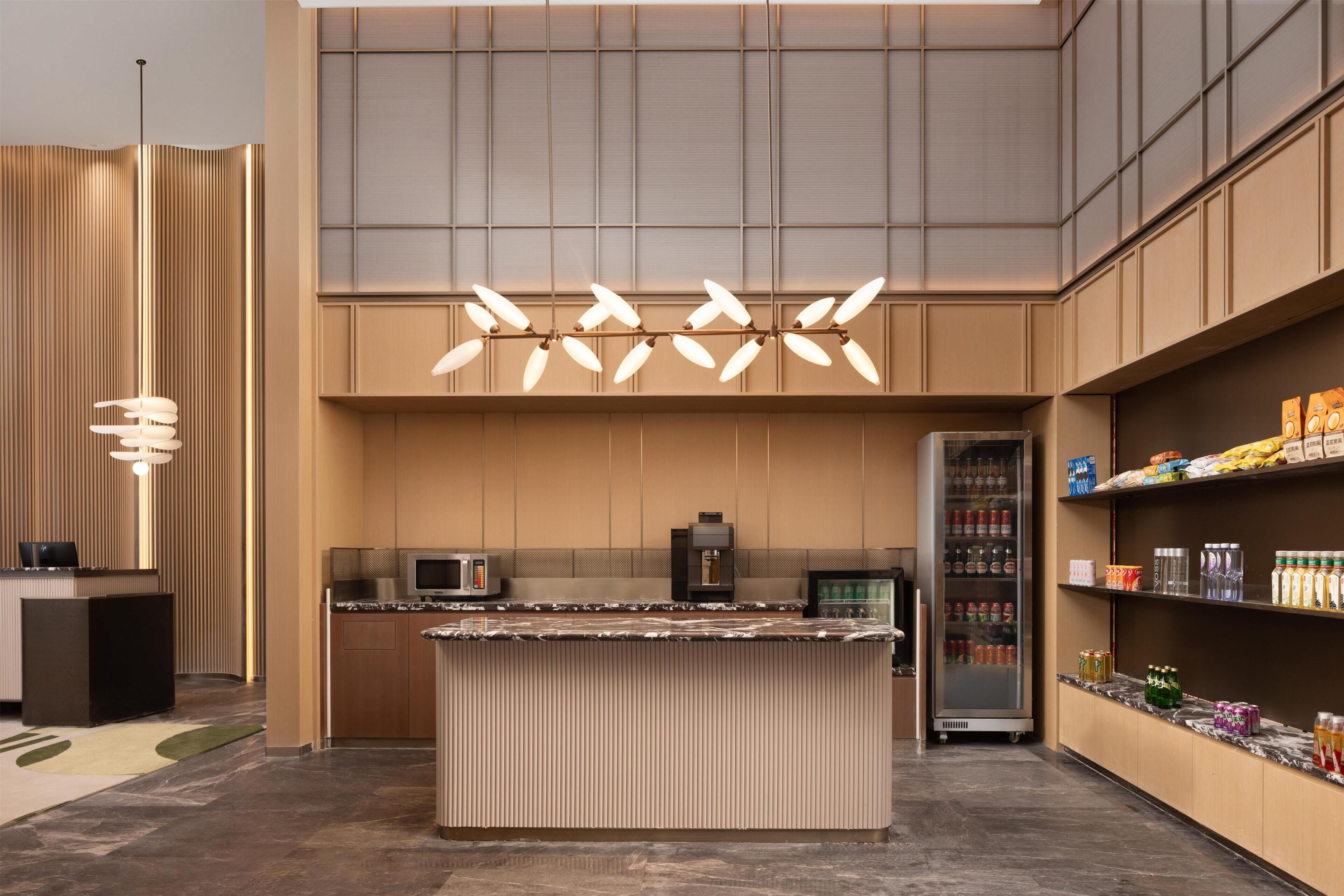 Cozinha moderna com ilha central, micro-ondas e frigorífico.