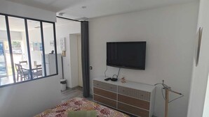 A bedroom with a bed, a TV, a dresser, and a window. - Apartment near Dune du Pilat (La Teste-de-Buch)