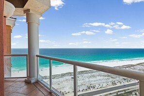 Ein Balkon mit Blick auf Strand und Meer.