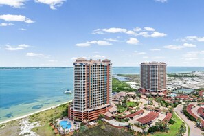 Zwei hohe Hotels mit Balkonen, einem Pool und Blick auf den Strand.