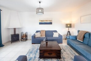 Ein Wohnzimmer mit einer Couch, einem Couchtisch, einer Lampe und einem Kamin.