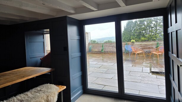 A room with a large sliding glass door leading to an outdoor patio area.