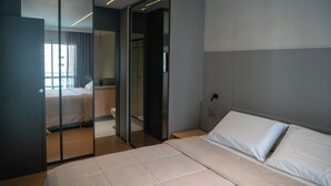 Un dormitori modern amb un llit gran, una separació de vidre i vista a un altre espai.