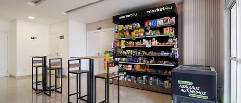Een net, modern interieur met een zelfbedieningskiosk genaamd 'market4u' en een automaat.