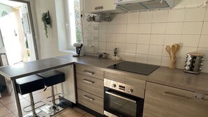 Una cucina moderna con forno integrato, lavello e finestra.