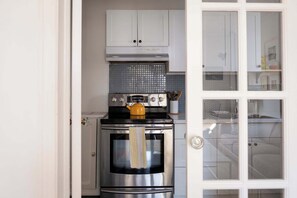 Une cuisine équipée d’une cuisinière, d’un four et de placards.
