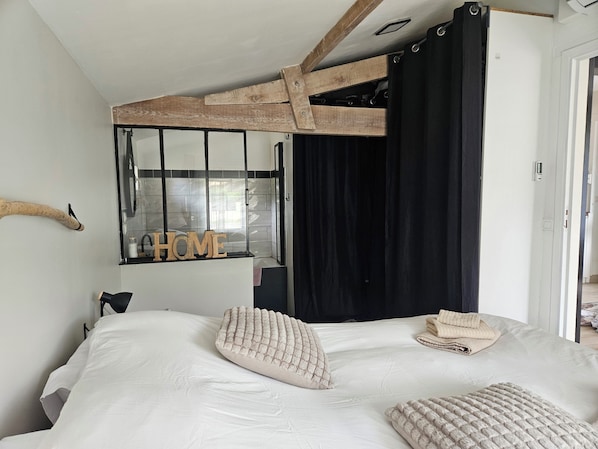 A bedroom with a bed, pillows, a 'HOME' sign, a window, and a door.