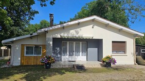 Una casa a un piano con un'entrata principale, un garage e un piccolo portico con piante in vaso.