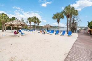 A beach with lounge chairs, palm trees, and a wooden deck. - Accessible Caribbean Retreat | Ground Floor (Davenport)