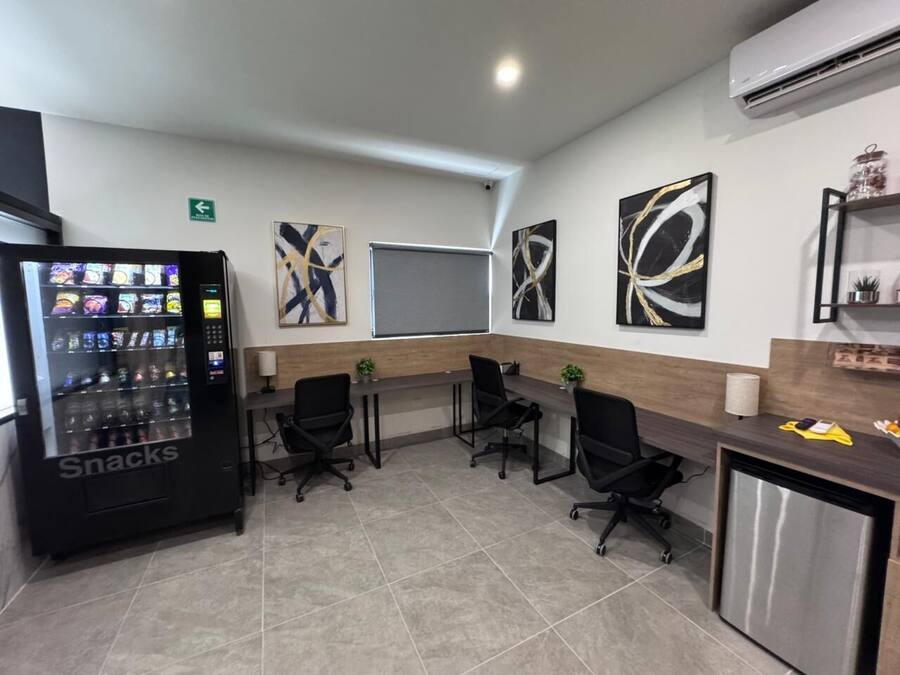 A conference room with a vending machine, a whiteboard, and abstract art on the walls.