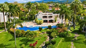 A resort with a swimming pool, palm trees, and a mountainous backdrop. - Villa, Garden View, 2-bedroom (Kihei)