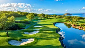 A golf course with a water body, trees, and a distant mountain. - Villa, Garden View, 2-bedroom (Kihei)