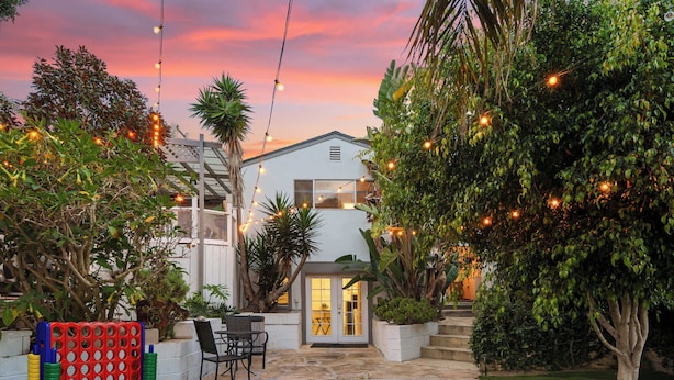 A house with a stone patio, a red and blue game table, and a white exterior. - Golden Hour Overlook | Spa | In-Law Suite | Grill (San Diego)