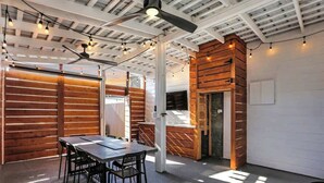 Un interior moderno con techos a la vista, paneles de madera, una zona de comedor con mesa y sillas, y una chimenea.