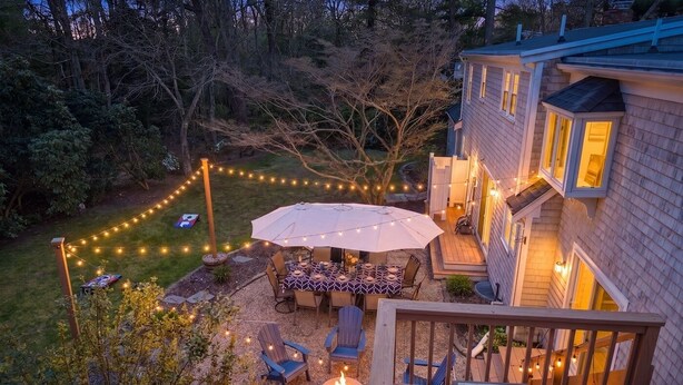 Une terrasse dotée de mobilier d’extérieur, d’un foyer et de guirlandes lumineuses.