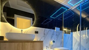 Une salle de bain moderne avec un grand lavabo sur colonne, un bidet et des toilettes.