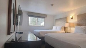 A hotel room with two beds, a TV, a window, and a lamp. - Hotel Palmas Quintero (Playas de Rosarito)