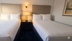 A hotel room with two single beds, a nightstand with a lamp, and a wall-mounted light fixture. - Hotel Palmas Quintero (Playas de Rosarito)