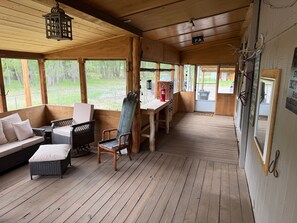 A wooden cabin with a porch, wicker furniture, and a view of the outdoors. - Alpine Dream | ATV, Fishing & Mountain Escape (South Fork)