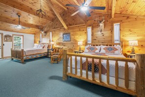 A cabin interior with a wooden ceiling, two beds, a ceiling fan, and deer antlers on the walls. - Alpine Dream | ATV, Fishing & Mountain Escape (South Fork)