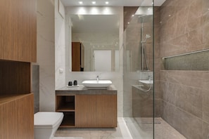 A modern bathroom with a wooden vanity, a large mirror, and a glass-enclosed shower area. - Nadmorski Dwór by Grand Apartments (Gdańsk)