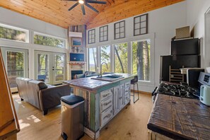 A spacious kitchen with a large island, wooden ceiling, and large windows. - 20-Acre Cabin • Hot Tub + Fire Pit • 6 Min to Dtwn Clayton • Black Rock Mt (Rabun Gap)