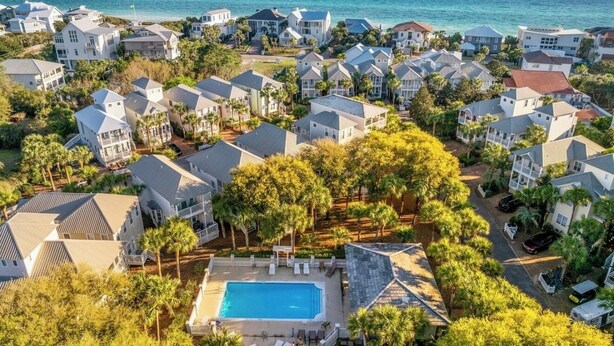 Una zona residencial costera con varias casas, una piscina y vista al océano.