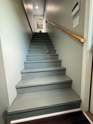 A staircase with a wooden handrail and a light-colored wall.