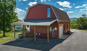 A red barn with a covered porch, a garage, and a utility box.