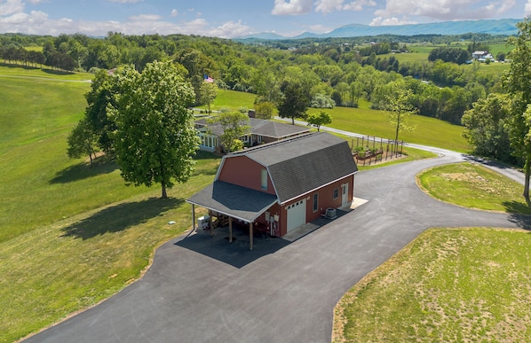 A rural property with a large barn, open fields, and a winding road.