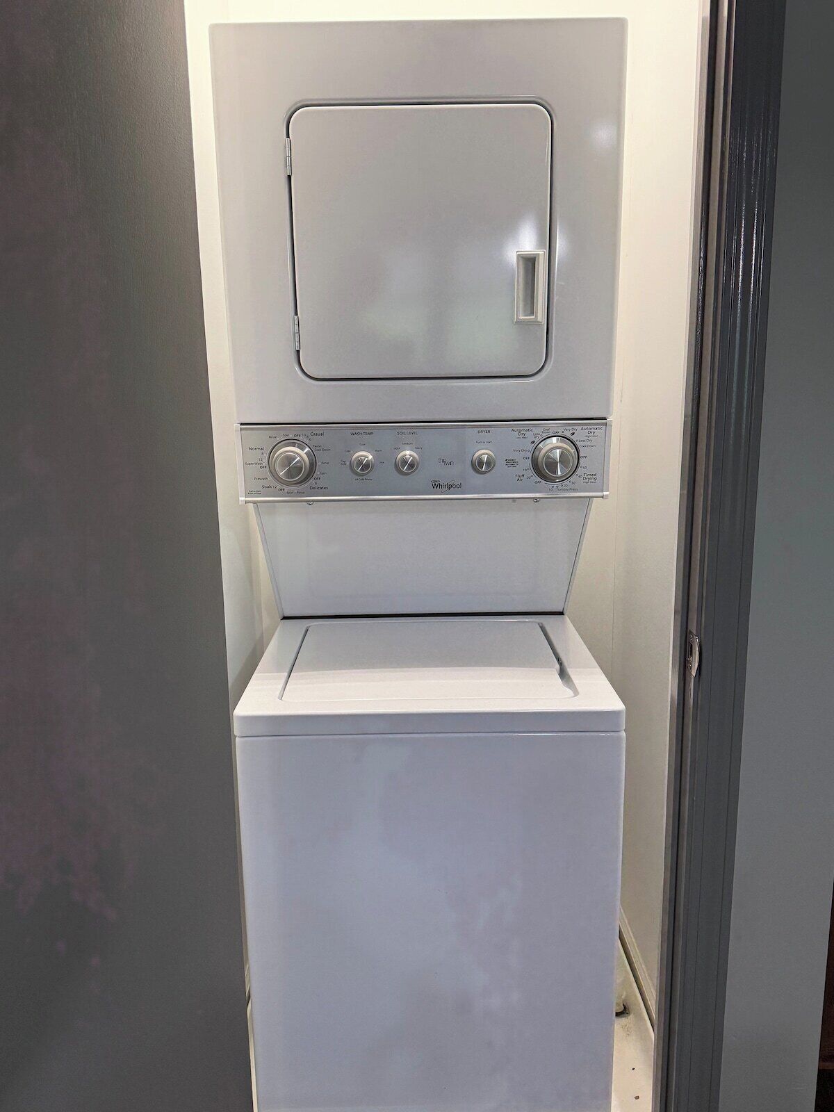 A compact, white, front-loading washer and dryer unit with a control panel featuring multiple settings.
