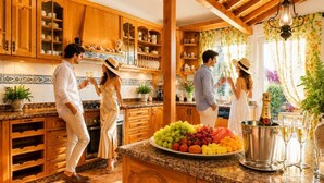 Una cocina con armarios de madera, encimera de mármol y una bandeja de frutas.