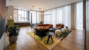 A modern living room with a sofa, coffee table, and a potted plant.