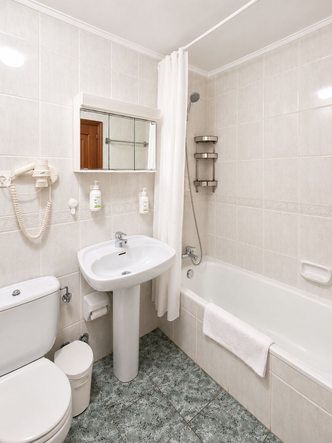 A bathroom with a toilet, sink, and bathtub.