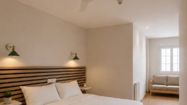 A bedroom with a bed, bedside tables, a ceiling fan, and a window. - Hotel Peña Pintada (Valdes)