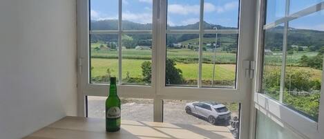 Habitación con vista a un paisaje verde a través de un ventanal amplio.