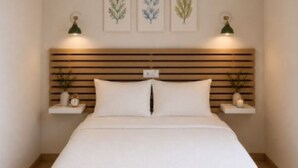A bedroom with a bed, a ceiling fan, wall-mounted shelves with decorative items, and framed botanical prints. - Hotel Peña Pintada (Valdes)