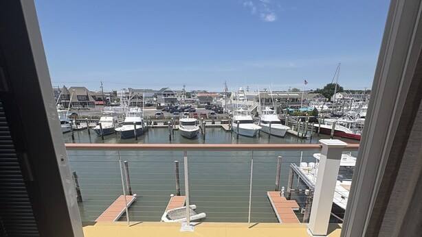 A marina with boats docked, a clear sky, and buildings in the background. - Relaxing Coastal Retreat in Cape May! Condo #8 (Cape May)