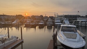 A marina with boats docked at wooden piers, a clear sky, and buildings in the background. - Relaxing Coastal Retreat in Cape May! Condo #8 (Cape May)
