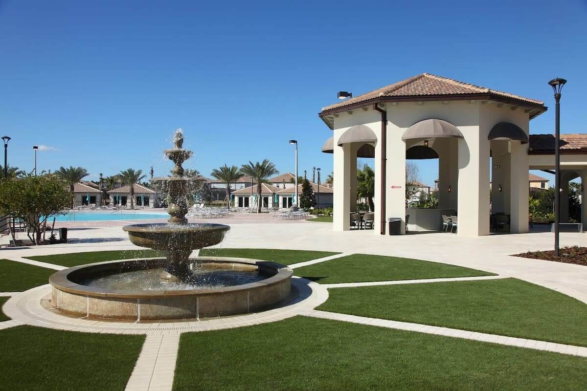 A fountain, a gazebo, and a pool in a landscaped area.