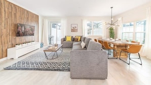 Una sala de estar moderna con un sofá, una mesa de centro y un comedor con una mesa de madera y sillas.