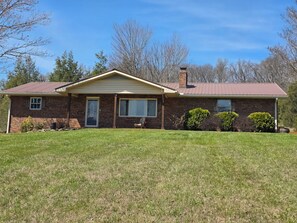 A two-story brick house with a front porch, a garage, and a well-maintained lawn. - Large brick home centrally located in Limestone. (Limestone)