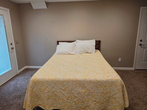A bedroom with a bed, a door, and a window. - Large brick home centrally located in Limestone. (Limestone)