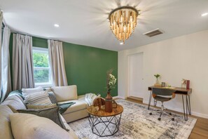 Ein Wohnzimmer mit einer Couch, einem Couchtisch und einem Schreibtisch mit Stuhl.